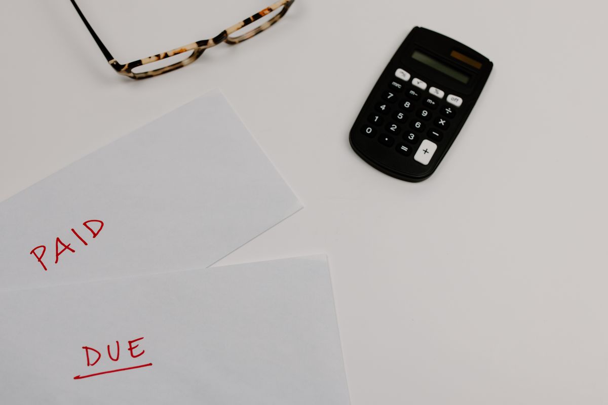 Invoices and a calculator laid out on a desk